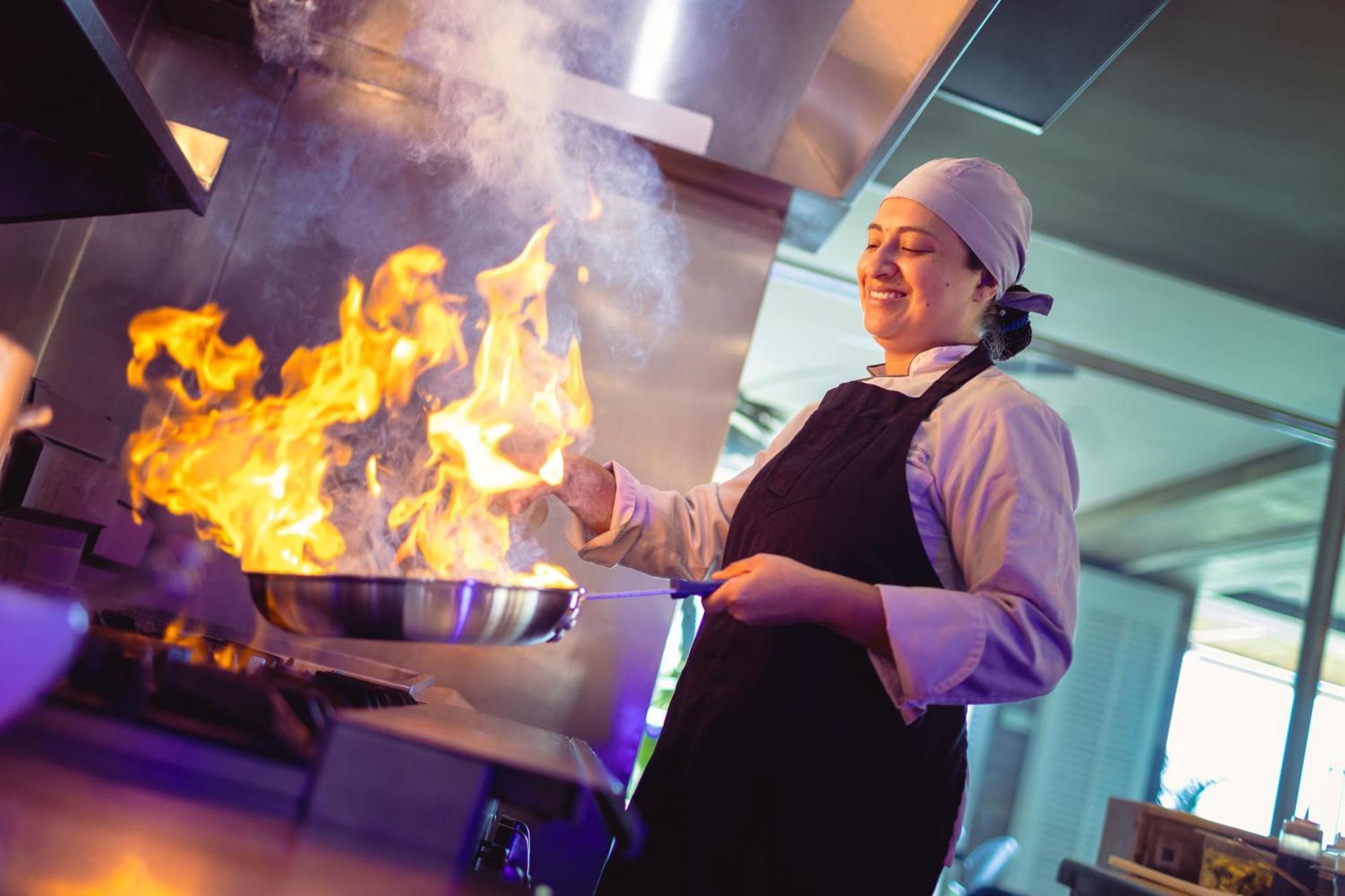 サンタ マルタ マリオット リゾート プラヤ ドルミーダ サンタ・マルタ エクステリア 写真 A chef cooking with a flaming skillet